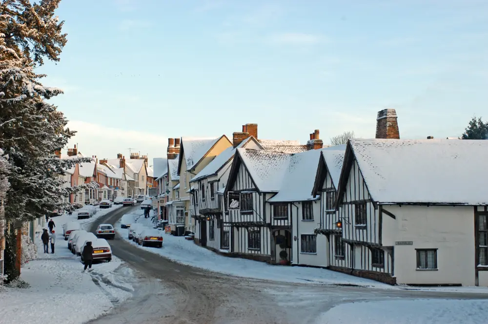 In the film, Godric’s Hollow was under snow. Once or twice a winter Lavenham does the effect for free, no studio required, and you can watch the whole thing from a window seat with a pot of tea.