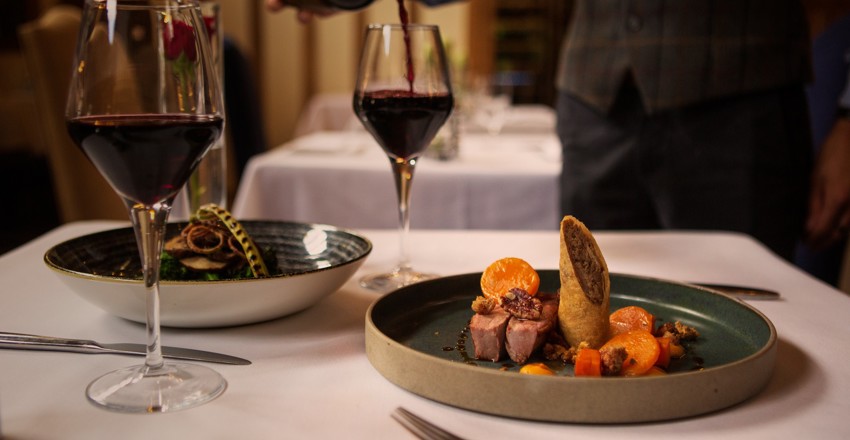 Dinner dishes with server pouring wine, The Gallery Restaurant, The Swan at Lavenham