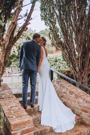 Bride and Groom kissing in entrance way to secret garden - Lottie Photography