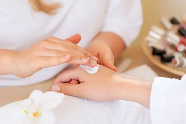 Client having hand massaged with product