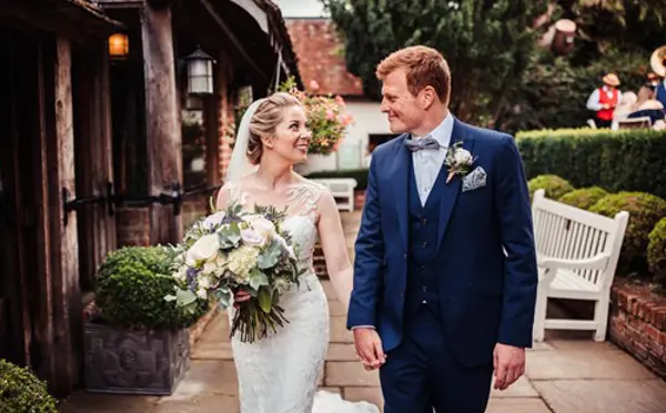 Bride and groom walking side by side in the garden
