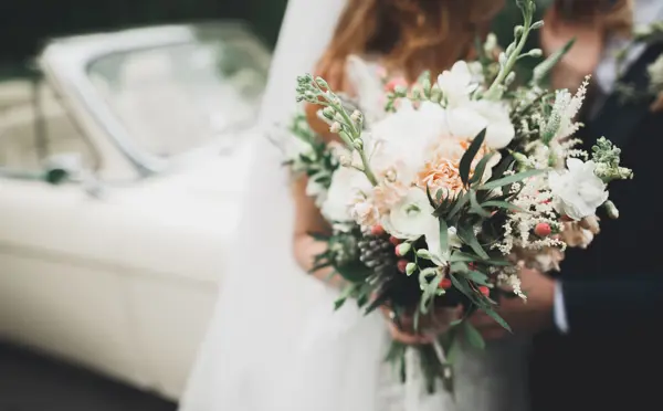 Beauty wedding bouquet with different flowers in hands