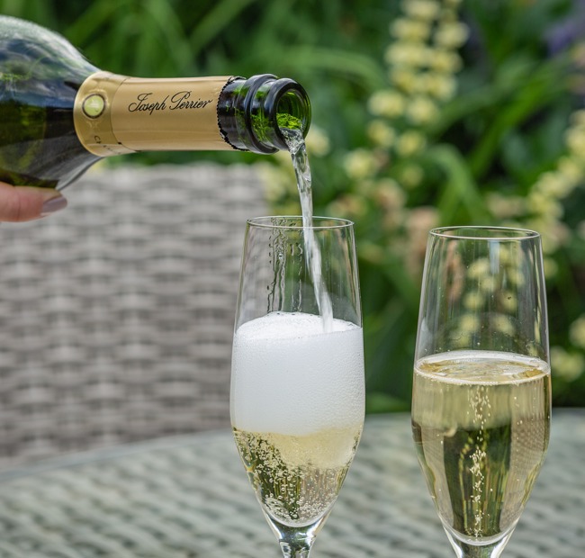 The Swan at Lavenham, pouring Champagne into glasses in the garden