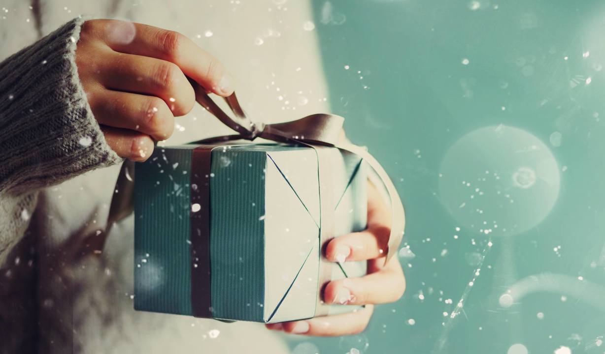 Christmas gift box with bow being unwrapped
