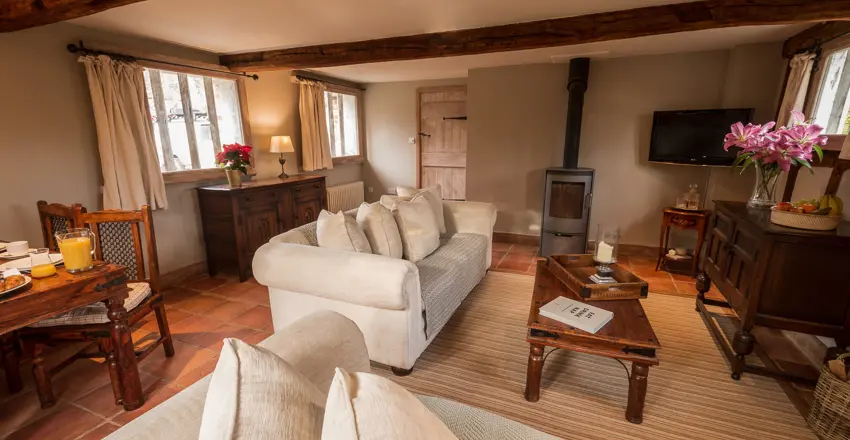 The Dairy, self catering in Lavenham, lounge with sofas, log burner and coffee table