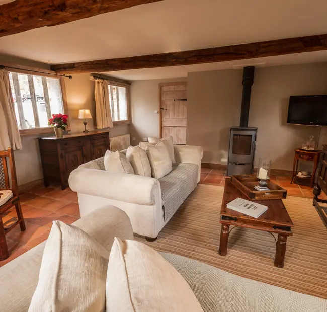 The Priory Dairy, Lavenham, self-catering, lounge with sofa, coffee table, log burner, TV and dining table