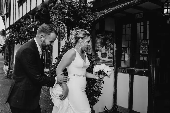 Bride and Groom running back into hotel to avoid the rain! - Lottie Photography