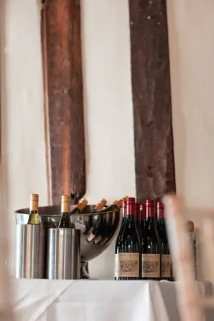 Wine bottles lined up against beamed wall - Steve Harrowing Photography