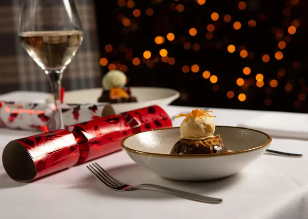 Festive dessert on table with cracker and glass of wine