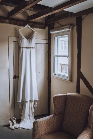 Bride's dress hanging in bedroom - Lottie Photography